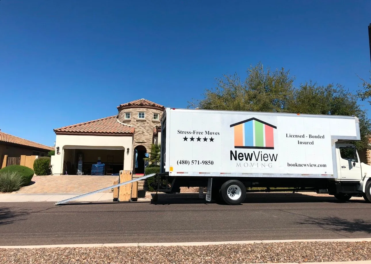 A NewView truck parked outside a customer home with the loading ramp down